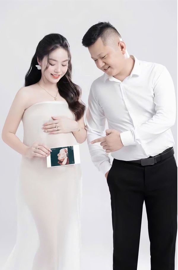 Hai vợ chồng cùng cầm tấm ảnh siêu âm của con
